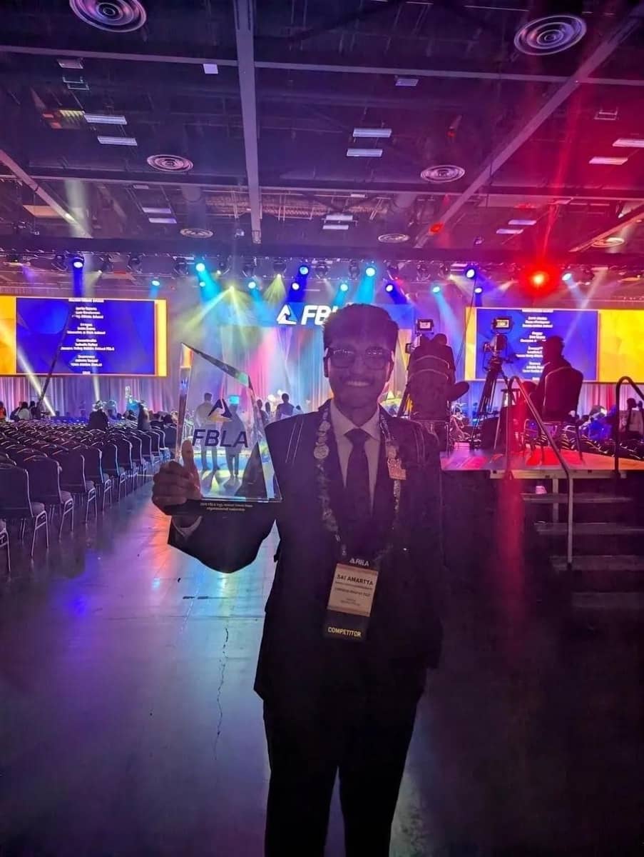 Sai Amartya holding the FBLA glass award on the arena floor of the National Leadership Conference in San Antonio.